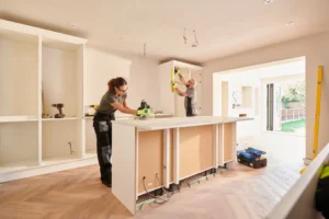 Kitchen renovation with two workers installing cabinets.
