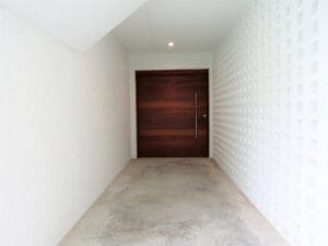 White hallway with wooden door