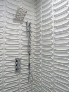Stylish shower featuring patterned white tiles