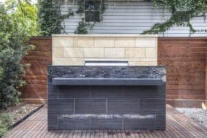 Modern backyard grill with wooden fence