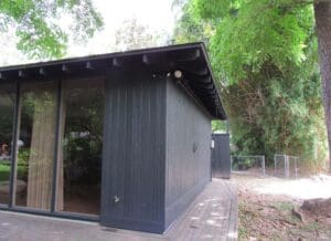 Dark wooden cabin with large windows