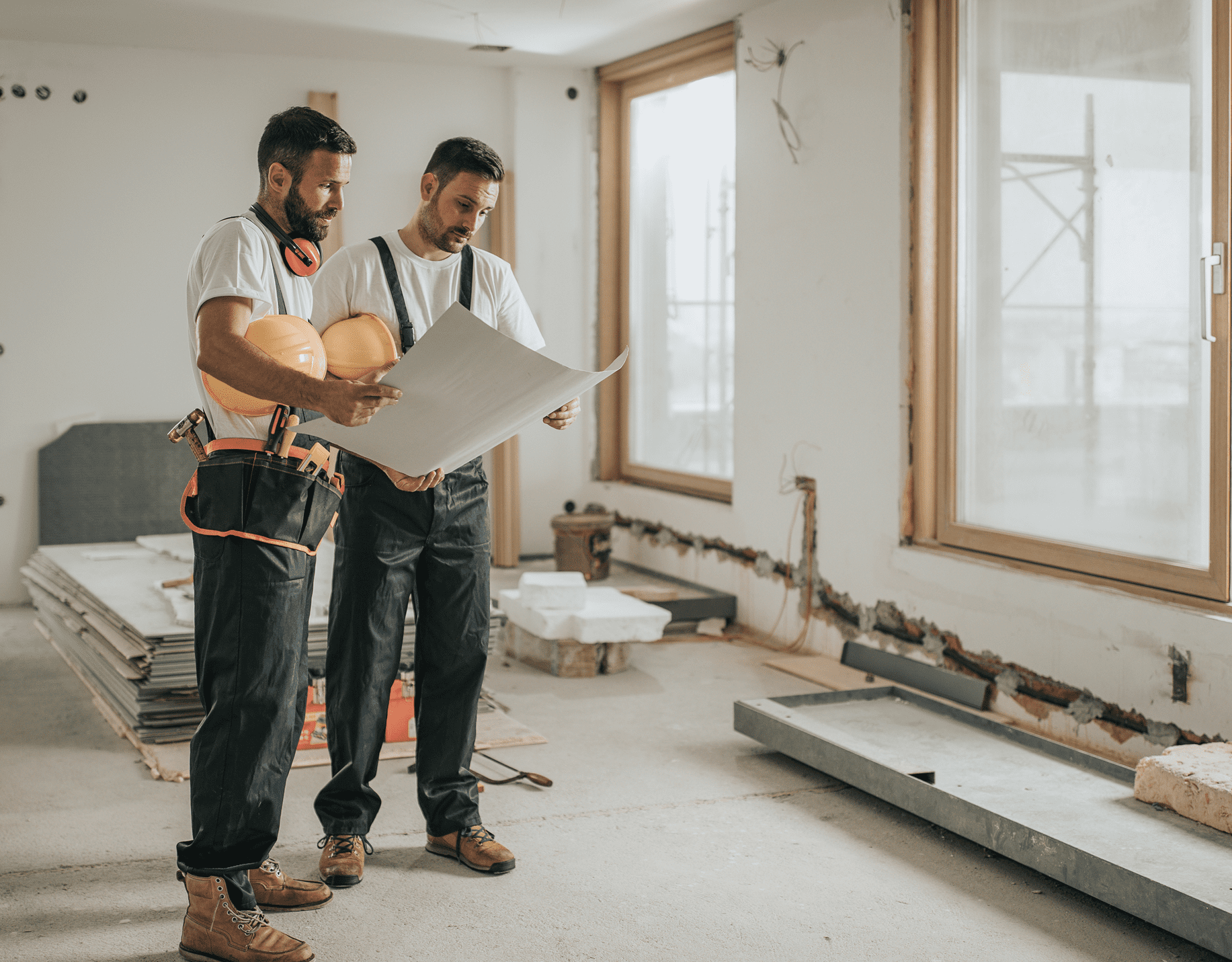 Two construction workers examining building plans.
